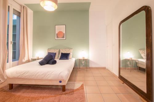 una camera con un letto e un grande specchio di Grand 3 Pièces Central et Calme a Mentone