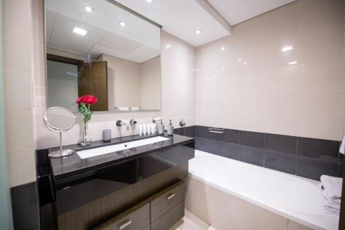 a bathroom with a sink and a mirror at OSKENA Vacation Homes -The Lofts Boulevard Downtown in Dubai