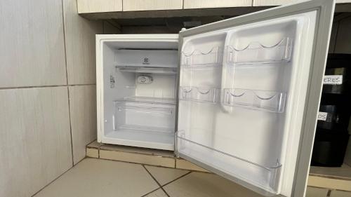 an empty refrigerator with its door open in a kitchen at Casa 4 hospedagem seropedica in Seropédica
