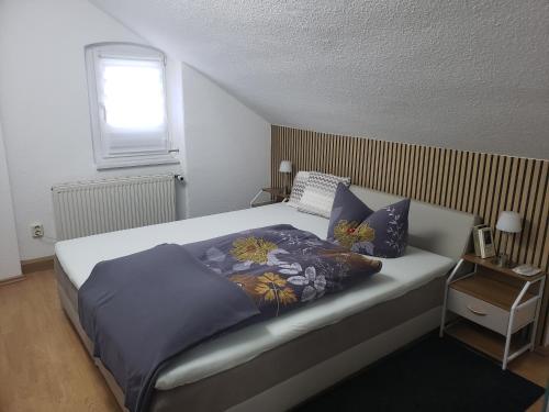 a bedroom with a bed with blue sheets and a window at Ferienapartements Girrbach in Dresden