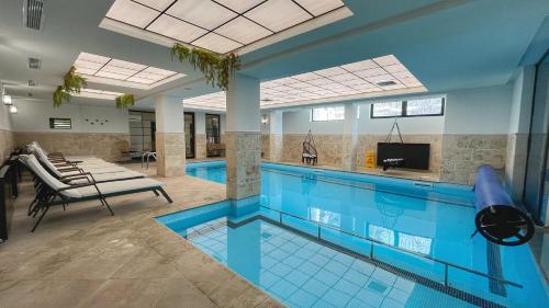 a large swimming pool with blue tile floors and a swimming pool at Апартамент Горска приказка - Forest tale in Smolyan
