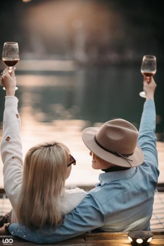 a man and a woman sitting on a bench with glasses of wine at Lan Ha Floating Homestay in Cat Ba