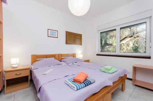 a bedroom with a bed with two towels on it at Gonar 300 Rab in Supetarska Draga