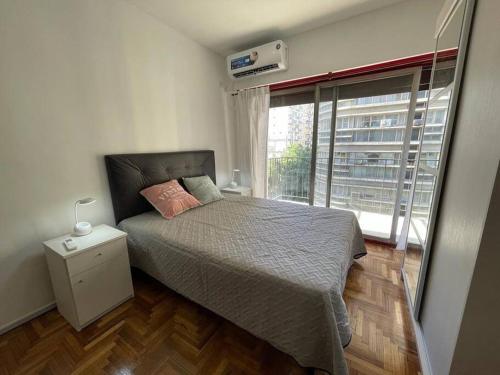 1 dormitorio con cama y ventana grande en Hermoso departamento en el Centro de Buenos Aires- Viamonte 3 en Buenos Aires