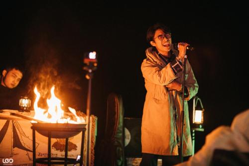 a man singing into a microphone next to a fire at Lan Ha Floating Homestay in Cat Ba