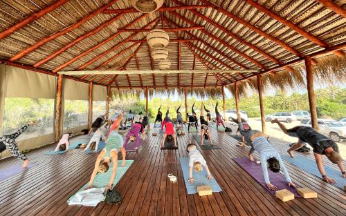 a group of people doing yoga in a pavilion at Kumba Lodge in Praia do Tofo