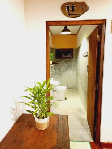 une salle de bains avec deux toilettes et une table avec une plante dans l'établissement Coco Garden Villas 1, à Hikkaduwa