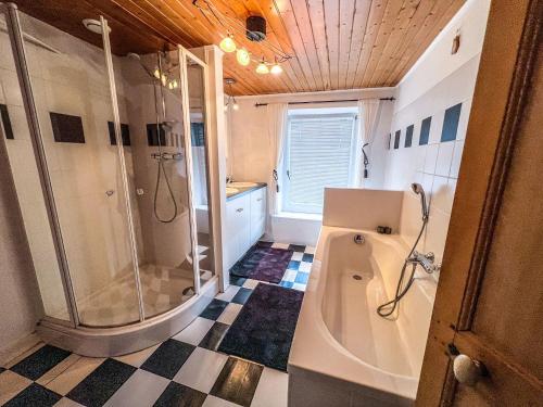 y baño con ducha, bañera y lavamanos. en La Maison Hôte, gîte de charme en bord de Semois, en Bouillon