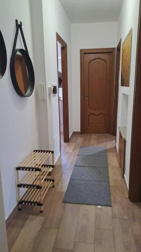 a hallway with a door and a rug and a wooden floor at Edoardoapartments in Vercelli