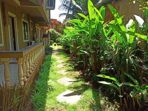 a garden path with plants next to a house at TGF Dream Guest House in Majorda