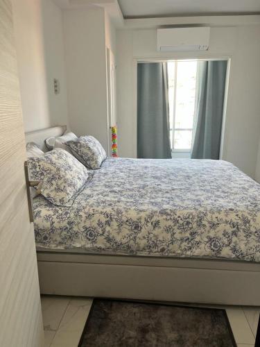 une chambre avec un lit avec une couette bleue et blanche dans l'établissement Le Grand Bleu, à Nice