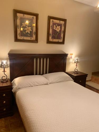 a bedroom with a bed and two pictures on the wall at DC Mesones 21 in Lerma