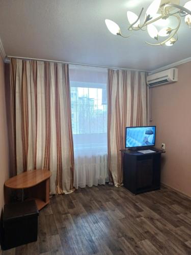 un soggiorno con TV e finestra di Апартаменти Іва з окремими кімнатами в самому центрі a Dnipro