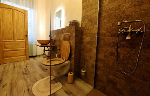 e bagno con doccia, servizi igienici e parete in mattoni. di Branko's Residence a Timişoara