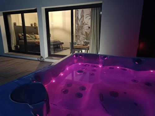 a hot pink tub in a room with a living room at lovebirds spa in Vincey