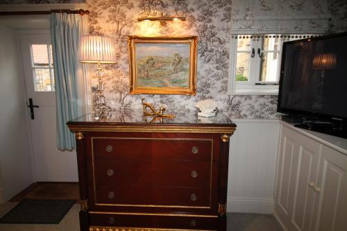 a dresser in a room with a picture on the wall at Mr Ralphs Cottage in Whitby