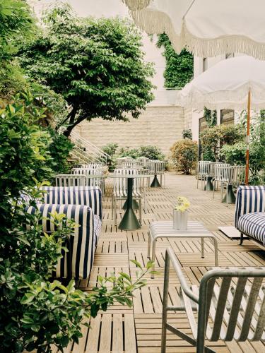 a patio with chairs and tables and trees at Hôtel Rosalie in Paris