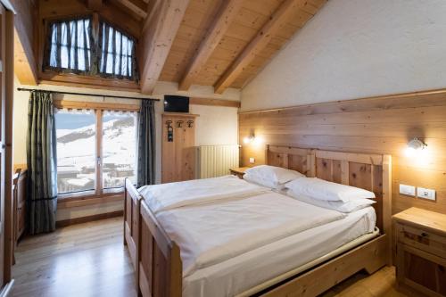 Un dormitorio con una cama grande y una ventana en Hotel Helvetia en Livigno