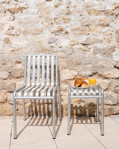 a metal chair and a table with a bowl of bread at Hôtel Rosalie in Paris