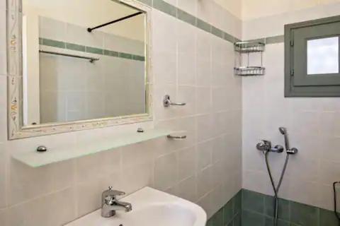 W białej łazience znajduje się umywalka i lustro. w obiekcie m.houses 2 w mieście Agios Romanos