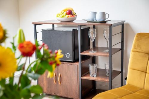 una mensola in legno con TV e cesto di frutta di Luxury Studio Apartment - Town Centre a Whitehaven