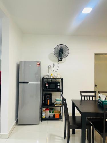 a kitchen with a stainless steel refrigerator and a table at SSHomestay in Skudai