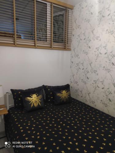 a bedroom with a bed with black and gold pillows at Apartament Miodownik in Międzylesie