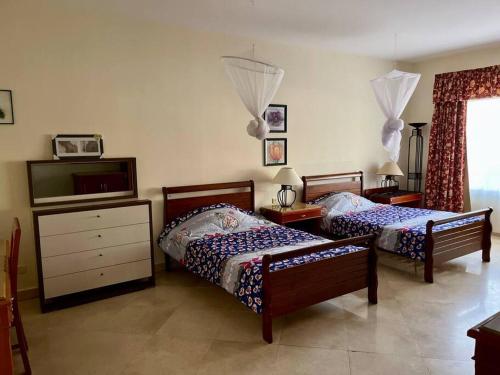 a bedroom with two beds and a dresser at Nabq Bay Amwaj Oyoun Hotel in Sharm El Sheikh