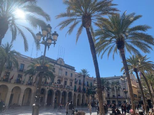 a group of palm trees in front of a building at L'Havana Xica in Vilanova i la Geltrú