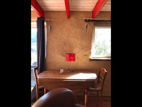 a wooden table in a room with a window at La vieille ferme in Landévennec