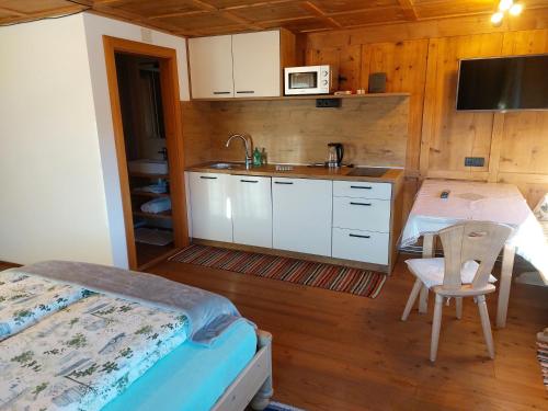 - une cuisine avec un lit et un évier dans la chambre dans l'établissement Gostnerhof, à Dobbiaco