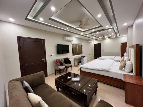 ein Schlafzimmer mit einem großen Bett und einem Sofa in der Unterkunft Grand Luxury Hotel Multan in Multan