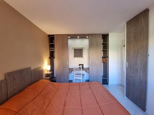 a bedroom with a large bed and a desk at Appartement Face a la Mer in Pornic