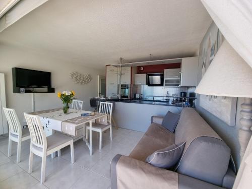 a living room and kitchen with a couch and a table at Appartement Face a la Mer in Pornic