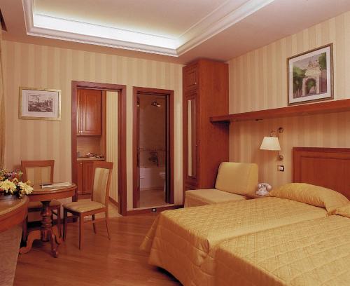 ローマにあるPiave and Flavia apartmentsのベッドルーム1室(ベッド1台、テーブル、椅子付)