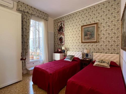 a bedroom with two beds and a window at B&B Beroni a Venezia in Venice