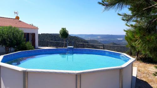 a large swimming pool on the side of a house at Casa Rural Mas de les Àligues in Mequinenza