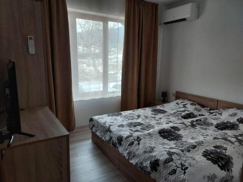 een slaapkamer met een bed en een raam bij 4 Seasons 2 - Top Lodge in Bansko