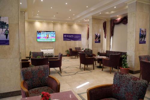 a waiting room with tables and chairs and a tv at Cairo international Scout House in Cairo