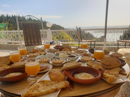 a table full of food and glasses of orange juice at Ferme Bouhouch in Oulad Yakoub