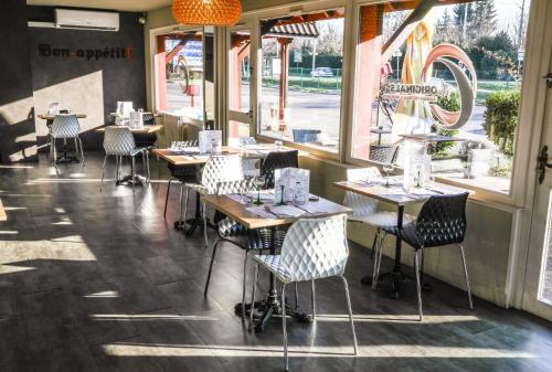 a row of tables and chairs in a restaurant at The Originals City, Hôtel Mulhouse Est in Rixheim