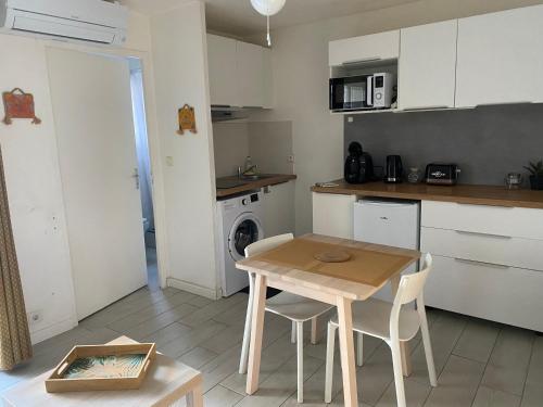 eine Küche mit einem Holztisch sowie einem Tisch und Stühlen in der Unterkunft Studio à 20m de la plage in Palavas-les-Flots
