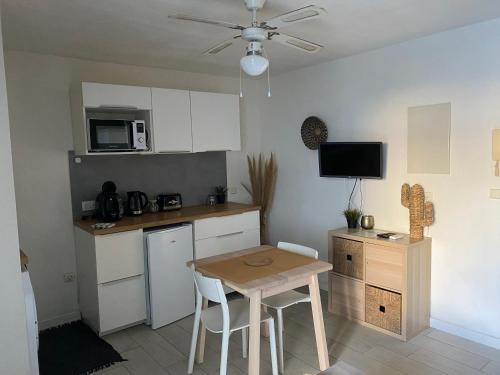 eine Küche mit einem Tisch und eine kleine Küche mit einer Mikrowelle in der Unterkunft Studio à 20m de la plage in Palavas-les-Flots