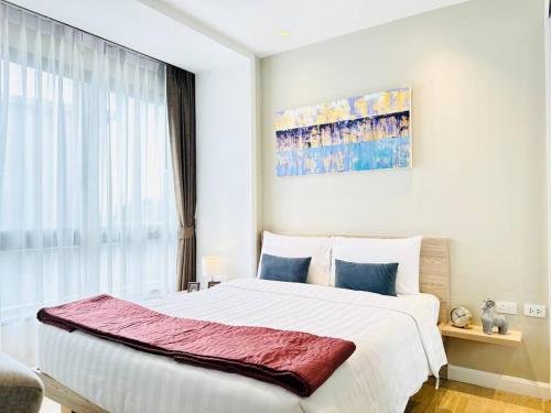 a bedroom with a large white bed and a window at Daimond Exclusive Junior Suite Bangtau Beach in Bang Tao Beach