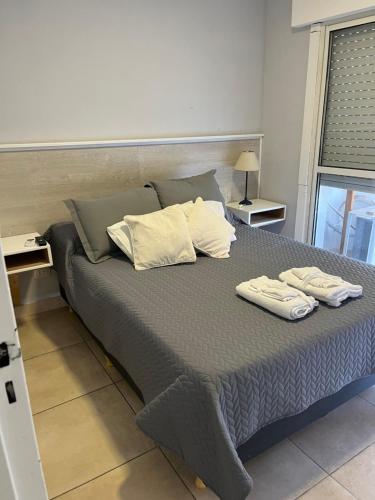 a bedroom with a large bed with two towels on it at New Apartment Talampaya in La Rioja