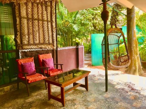 a porch with two chairs and a coffee table at Marari Dreamz Homestay in Mararikulam