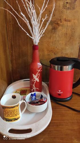 a tray with a cup of coffee and a red vase at Hotel Shiv Palace in Tehri-Garhwāl