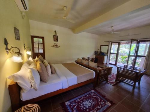 a bedroom with a bed and a desk in a room at Mandaram villas in Mararikulam