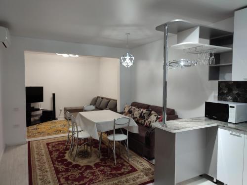 奇姆肯特的住宿－"AIKO" Konak Otbasy，厨房以及带桌子和沙发的客厅。