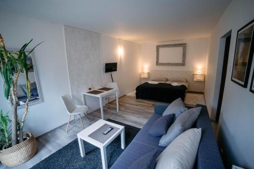 a living room with a blue couch and a bed at Alt pension in Prague